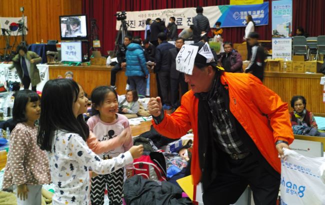 [사진=자원봉사자로 경북 포항 흥해실내체육관 대피소를 찾은 원승재(70) 씨가 지진 피해로 대피소에 머무는 아이들을 응원하고 있다.]