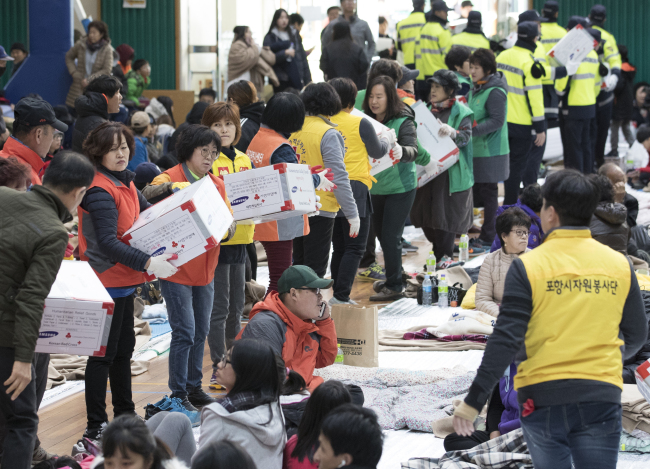 규모 5.4지진이 발생한지 하루가 지난 16일 오전 시민들이 대피해있는 포항시 흥해실내체육관에서 자원봉사자들이 구호품을 나르고 있다.[사진제공=연합뉴스]