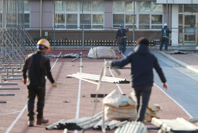 19일 오후 경북 포항시 북구 흥해초등학교에서 작업자들이 복구작업을 하고 있다. 이 학교는 지난 15일 발생한 규모 5.4 지진으로 외벽이 부서지는 등 피해가 났다. [사진제공=연합뉴스]