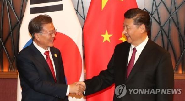 South Korean President Moon Jae-in (L) shakes hands with Chinese President Xi Jinping before their bilateral summit held on the sidelines of the Asia-Pacific Economic Cooperation Economic Leaders` Meeting in Danang, Vietnam, on Nov. 11, 2017. (Yonhap)