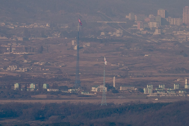 군 당국이 북한 군인 귀순 사건을 계기로 판문점 공동경비구역(JSA)에서 ‘한국군 교전수칙’을 적용하는 방안을 검토 중인 것으로 알려진 가운데 20일 경기도 파주시 접경지역에서 비무장지대(DMZ) 내 남한 대성동 마을의 태극기와 북한 기정동 마을의 인공기가 마주서 있는 모습이 보이고 있다. [사진=연합뉴스]