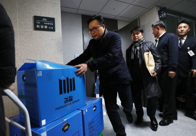 Investigators remove records from Rep. Choi Kyung-hwan`s office at the National Assembly on Monday. Yonhap