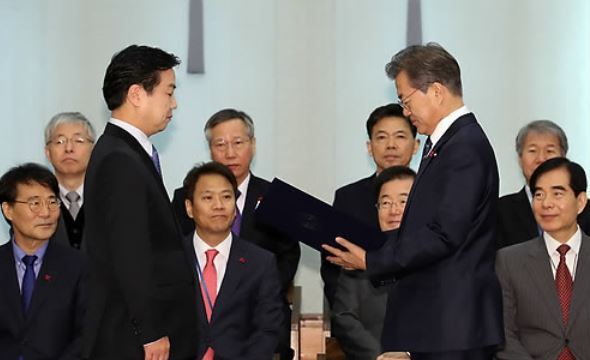 President Moon Jae-in (standing, R) presents Hong Jong-haak, the new minister of SMEs and startups, with a letter of appointment in a ceremony held at the presidential office Cheong Wa Dae in Seoul on Nov. 21, 2017. (Yonhap)