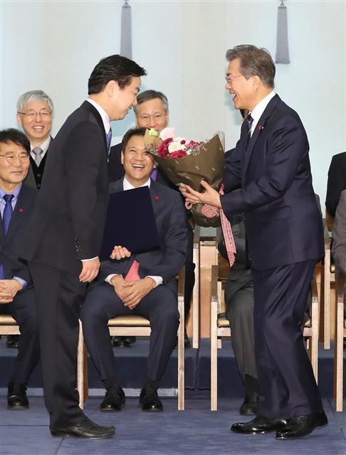 문재인 대통령이 21일 오전 청와대 본관 충무실에서 홍종학 중소벤처기업부 장관에게 임명장을 수여한 뒤 꽃다발을 건네며 밝게 웃고 있다. [연합뉴스]