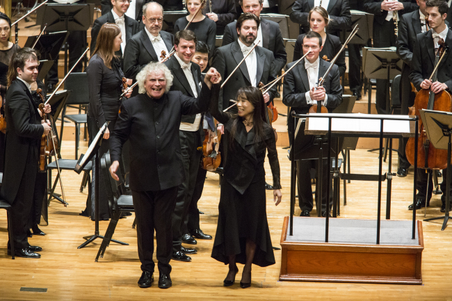 Simon Rattle (left), raises composer Chin Un-suk`s arm after the Korean premiere of "Choros Chordon" by the Berlin Philharmonic Orchestra at Seoul Arts Center on Monday. (Kumho Asiana Cultural Foundation)