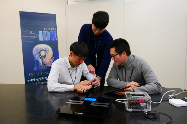[사진=ETRI연구진이 오픈커넥티비티재단(OCF) 헬스케어 사물인터넷 표준을 적용한 헬스케어 기기들을 연동 시험 중이다. 제공=ETRI]