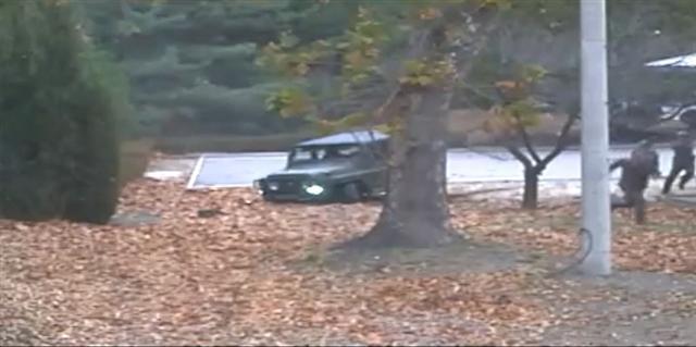 지난 13일 판문점 공동경비구역(JSA)에서 귀순 북한 병사가 지프 차량에서 내려 북한 군의 총격을 맞으며 남쪽으로 달리고 있다. 유엔군 사령부는 22일 최근 판문점공동경비구역(JSA)을 통해 귀순한 북한 병사의 당시 총격 상황을 담은 CCTV를 공개했다. [유엔군사령부 제공=연합뉴스]