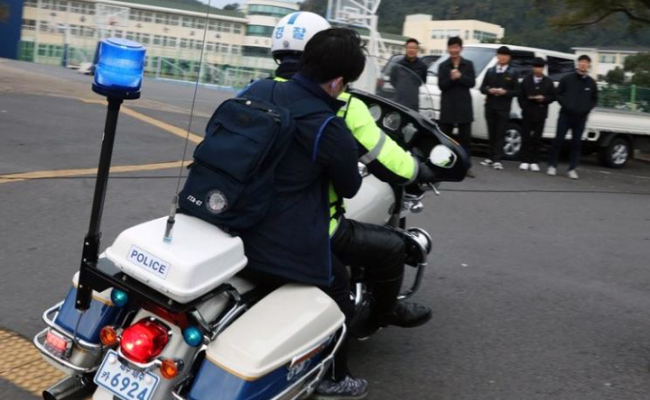 A police officer escorting a student to the Suneung test center. (Yonhap)