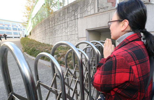 대학 수학능력시험일인 23일 오전 경북 포항 이동중학교 고사장 앞에서 수험생의 어머니가 손을 모으고 있다. [사진제공=연합뉴스]