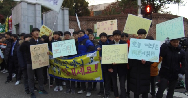 Well-wishers cheer for suneung test takers as they enter Yongsan High School in Seoul on Thursday. (Lim Jeong-yeo/The Korea Herald)