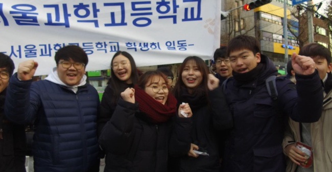 Well-wishers cheer for suneung test takers as they enter Yongsan High School in Seoul on Thursday. (Lim Jeong-yeo/The Korea Herald)