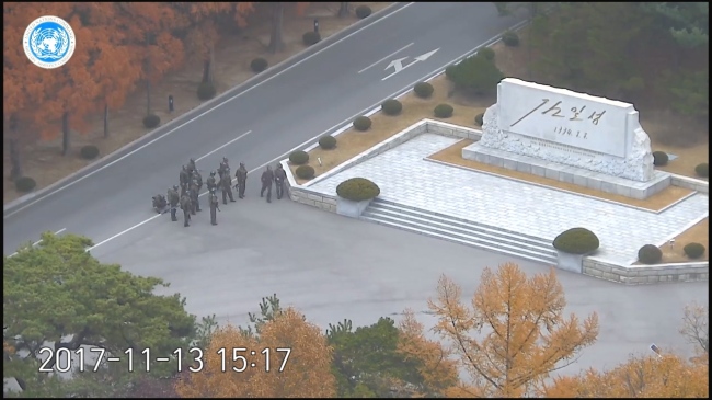 지난 13일 북한군 병사가 판문점 공동경비구역(JSA) 군사분계선을 넘은 뒤 북한군 경비병력이 북측 JSA 구역에 집결해있다. [사진=유엔사 CCTV 영상 캡처]