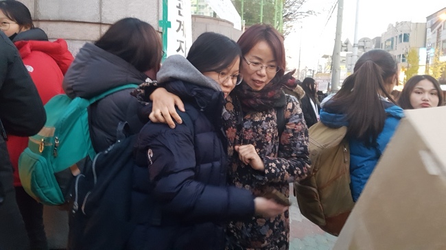 24일 지진의 공포 속에서 2018학년도 수학능력시험이 무사히 치러진 뒤 학생들이 마중나온 학부모에게 안겨 있다.