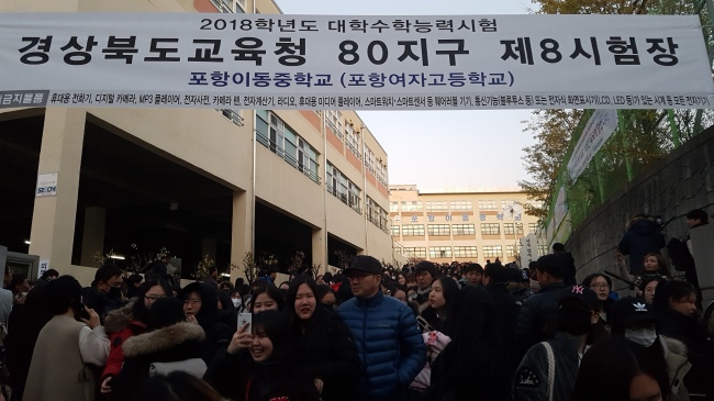 24일 지진의 공포 속에서 2018학년도 수학능력시험이 무사히 치러진 뒤 학생들이 마중나온 학부모에게 안겨 있다.