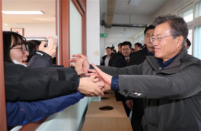 문재인 대통령이 24일 오전 지진으로 인해 특별재난지역으로 지정된 경북 포항시 북구의 포항여고를 방문해 수능을 마친 고3 학생들과 인사를 하고 있다. [연합뉴스]