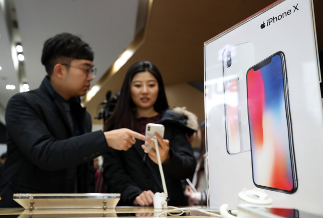 IPHONE X IN SEOUL -- Customers check out the iPhone X at the KT Square in Gwanghwamun of Seoul, Friday. The iPhone X, which Apple designed as its 10th anniversary smartphone, officially became available for purchase through Korea’s three mobile carriers SK Telecom, KT and LG Uplus on the day. (Yonhap)