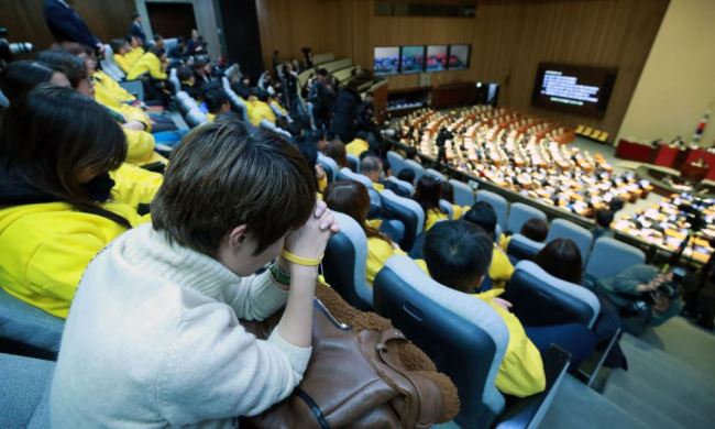 Family members of the Sewol ferry sinking victims watch from the National Assembly's main chamber as the parliament holds a final vote on a bill that calls for reinvestigations of major disasters, including the 2014 ferry sinking.(Yonhap)