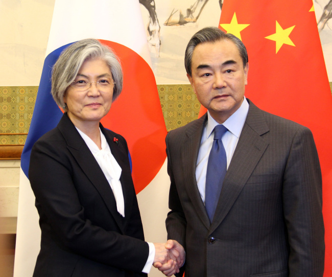 South Korea's Foreign Minister Kang Kyung-hwa shakes hands with his Chinese counterpart Wang Yi. Yonhap
