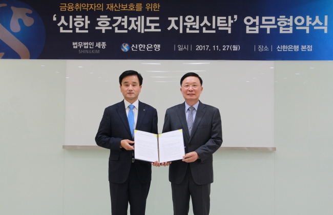 지난 27일 서울시 중구 세종대로 소재 신한은행 본점에서 진행된 ‘금융취약자의 재산보호를 위한 신한 후견제도 지원신탁 활성화 업무협약’을 마친 후 신한은행 신탁연금그룹 박우혁 부행장(왼쪽)과 법무법인 세종 강신섭 대표번호사가 기념촬영하고 있다. [사진제공=신한은행]