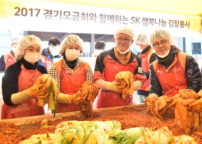 SK네트웍스 최신원 회장과 박상규 사장 및 임직원들이 29일 경기도 수원시에서 진행된 ‘2017 행복나눔 김장행사’에서 직접 담근 김치를 들어 보이고 있다. [사진제공=SK네트웍스]