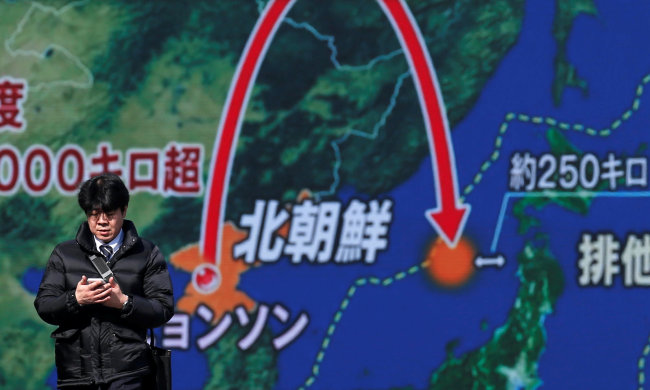 A man walks past a street monitor showing a news report about North Korea's missile launch in Tokyo on Wednesday. (Reuters-Yonhap)