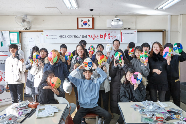 금호타이어는 29일 서울 구로구 오류중학교에서 학생들을 대상으로 청소년 미술치료 프로그램을 실시했다. 프로그램에 참가해 본인이 만든 가면을 들고 포즈를 취하고 있는 학생들의 단체사진 [제공=금호타이어]