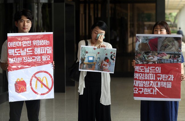 지난 7월5일 서울 서초동 서울중앙지검 앞에서 용혈성요독증후군 진단을 받은 A(4)양의 어머니 최은주 씨(가운데)가 기자회견 도중 눈물을 흘리고 있다. 최 씨는 맥도날드 해피밀 세트를 먹은 딸이 신장장애를 갖게 됐다며 이날 검찰에 한국맥도날드 유한회사에 대한 고소장을 접수했다. [사진제공=연합뉴스]