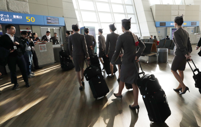 Asiana Airlines flight attendants bound for Bali, Indonesia, wait to board the aircraft on a special mission to bring back South Korean tourists who are stranded on the resort island amid warnings of imminent volcano eruption there. (Yonhap)
