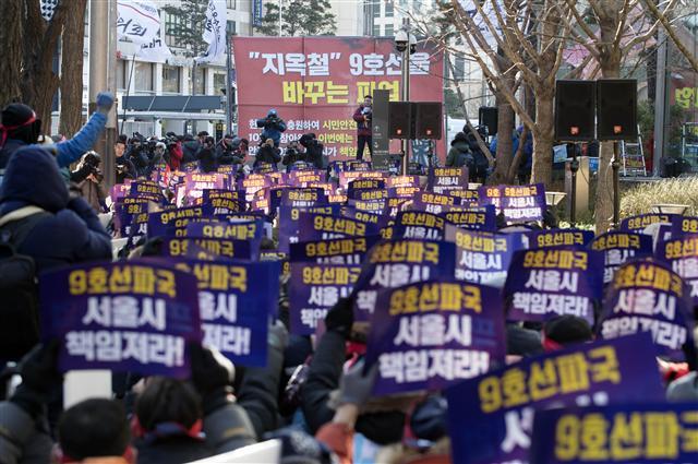 30일 오전 서울 중구 태평로1가 서울시청 앞에서 열린 9호선 총파업 출정식에서 참석자들이 서울시가 책임지라는 팻말을 들고 있다.  [연합뉴스]