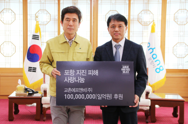 교촌에프앤비가 포항 지진피해 복구를 위해 후원한 성금 전달식에 참석한 황학수(오른쪽) 교촌에프앤비 사장과 이강덕 포항시장이 포즈를 취하고 있다.