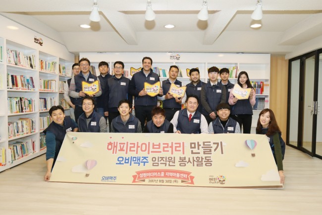 지난 달 30일 서울시 금천구 독산동 성원미디어스쿨 지역아동센터에서 해피 라이브러리의 완공을 앞두고 봉사활동에 참여한 오비맥주 임직원들이 기념사진을 촬영하고 있다.
