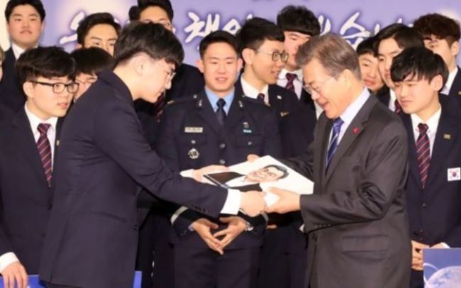 President Moon Jae-in (R) receives a caricature of himself as a gift from the South Korean team that competed at the World Skills Competition, held in Abu Dhabi in October, before the start of a special lunch with the team at his office Cheong Wa Dae in Seoul on Dec. 1, 2017. (Yonhap)