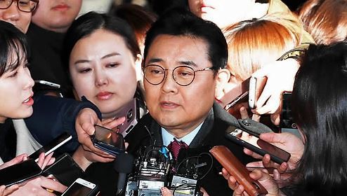 Jun Byung-hun, former senior aide to President Moon Jae-in, is swamped by reporters asking him questions as he appears at the Seoul Central District Prosecutors' Office for questioning over a bribery case on Dec. 4, 2017. (Yonhap)
