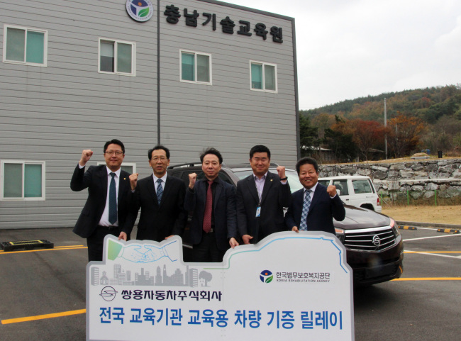 지난달 10일 쌍용자동차 충청지역본부 관계자들이 한국법무보호복지공단 홍성교도소에 코란도 투리스모와 변속기를 기증한 뒤 기념촬영을 하고 있다.[제공=쌍용자동차]