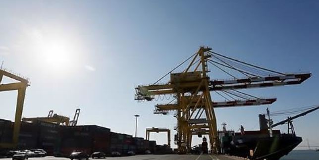 Giant cranes at the port of Incheon load containers onto a ship for export. (Yonhap)