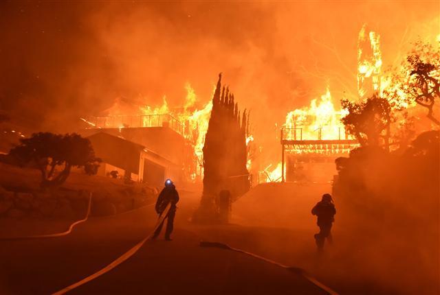 <YONHAP PHOTO-0890> In this photo provided by the Ventura County Fire Department, firefighters work to put out a blaze burning homes early Tuesday, Dec. 5, 2017, in Ventura, Calif. Authorities said the blaze broke out Monday and grew wildly in the hours that followed, consuming vegetation that hasn't burned in decades. (Ryan Cullom/Ventura County Fire Department via AP)/2017-12-06 03:24:06/ <저작권자 ⓒ 1980-2017 ㈜연합뉴스. 무단 전재 재배포 금지.>