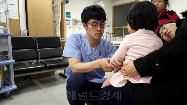 팔을 다쳐온 아이 환자를 달래고 있는 의사. [사진=정세희 기자/say@heraldcorp.com]