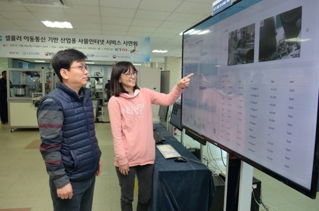ETRI연구진이 ‘셀룰러 이동통신 기반 산업용 사물인터넷 서비스’를 활용, 공장 운영 현황데이터를 살펴 보고 있다. [제공=ETRI]