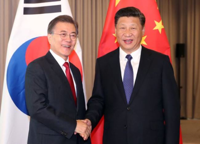 President Moon Jae-in and Chinese President Xi Jinping shake hands ahead of their summit at Intercontinental Hotel in Berlin, Thursday. (Yonhap)