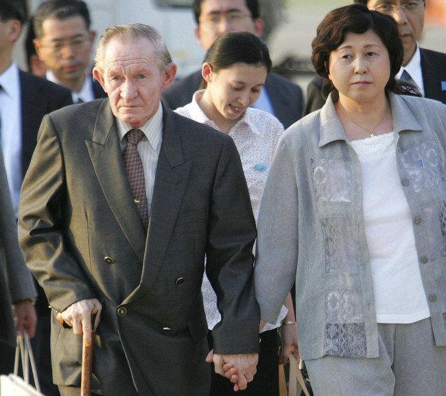 In this July 18, 2004 file photo, former U.S. Army deserter to North Korea, Charles Jenkins, left, escorted by his wife Hitomi Soga, right, and their daughter Mika, center, arrives at Tokyo's Haneda International Airport. Jenkins, who married Soga, a Japanese abductee and lived in Japan after their release in the 2000s, has died. He was 77.(AP-Yonhap)