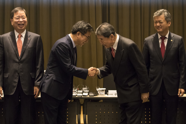 Finance Minister Kim Dong-yeon (second from left) shakes hands with LG Group Vice Chairman Koo Bon-joon at a press conference held at LG Twin Tower in Yeouido, western Seoul, Tuesday. (Yonhap)