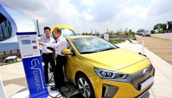 In this undated file photo, customers try to charge the all-electric Ioniq EV car. (Yonhap)