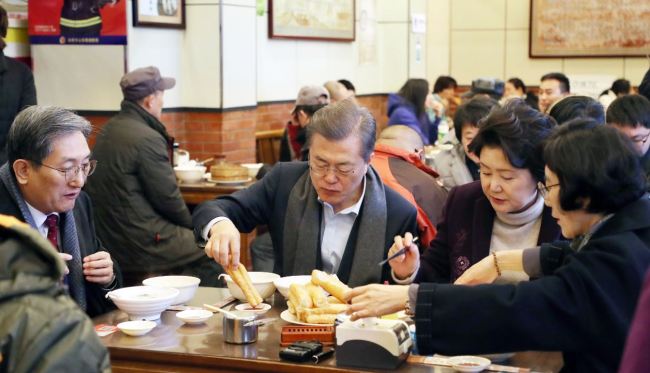 President Moon Jae-in (center) and First Lady Kim Jung-sook (Right) kicked off the second day of state visit to China with breakfast at a streetside restaurant in Beijing early Thursday.