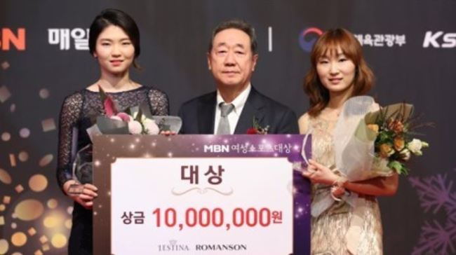 South Korean short track speed skaters Shim Suk-hee (L) and Choi Min-jeong (R) pose for a photo with Maekyung Media Group Chairman Chang Dae-whan after they won the grand prize at the MBM Women Sports Awards in Seoul on Dec. 14, 2017. (Yonhap)