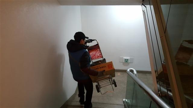 김 씨가 물건을 들고 계단으로 뛰는 모습.