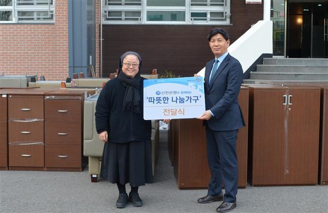15일 서울 은평구 구산동 소재 서울가톨릭 서울특별시립 은평의 마을에서 최용식 신한은행 서부본부장(오른쪽)과 이향배 은평의마을 원장이 사무가구 전달식 후 기념사진을 촬영하고 있다. [제공=신한은행]