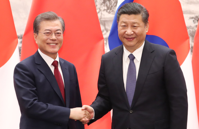 South Korea's president Moon Jae-in shakes hands with his Chinese counterpart Xi Jingping. Yonhap