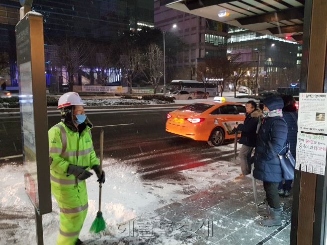 18일 새벽 서울 강남구 한 버스정류장에서 폭설로 출근길 시민들이 몰린 가운데 환경미화원이쌓인 눈을 치우고 있다(왼쪽 사진). 서울 광화문 일대에서 서울 등 수도권에 내린 기습폭설로 인해 시민들이 지하철로 몰려 출근하고 있다.  유오상·정세희 기자/osyoo@heraldcorp.com