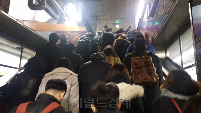 18일 새벽 서울 강남구 한 버스정류장에서 폭설로 출근길 시민들이 몰린 가운데 환경미화원이쌓인 눈을 치우고 있다(왼쪽 사진). 서울 광화문 일대에서 서울 등 수도권에 내린 기습폭설로 인해 시민들이 지하철로 몰려 출근하고 있다.  유오상·정세희 기자/osyoo@heraldcorp.com