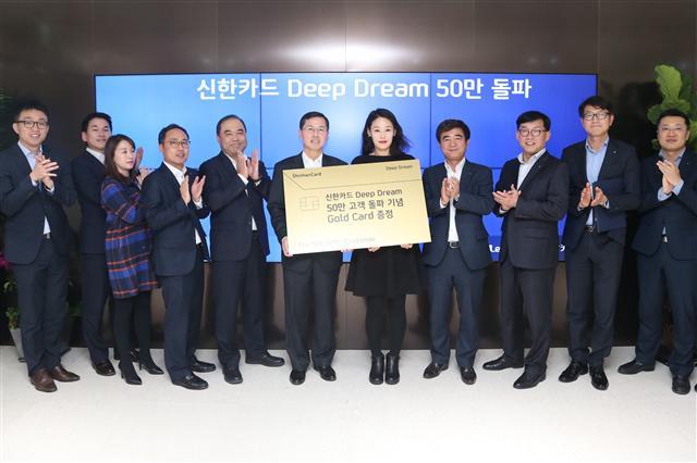 임영진 신한카드 사장(왼쪽 6번째)이 서울 을지로 본사에서 ‘딥 드림 카드’ 50만번째 발급 고객(왼쪽 7번째)에게 기념 선물을 전달하고 직원들이 이를 축하하고 있다. [제공=신한카드]
